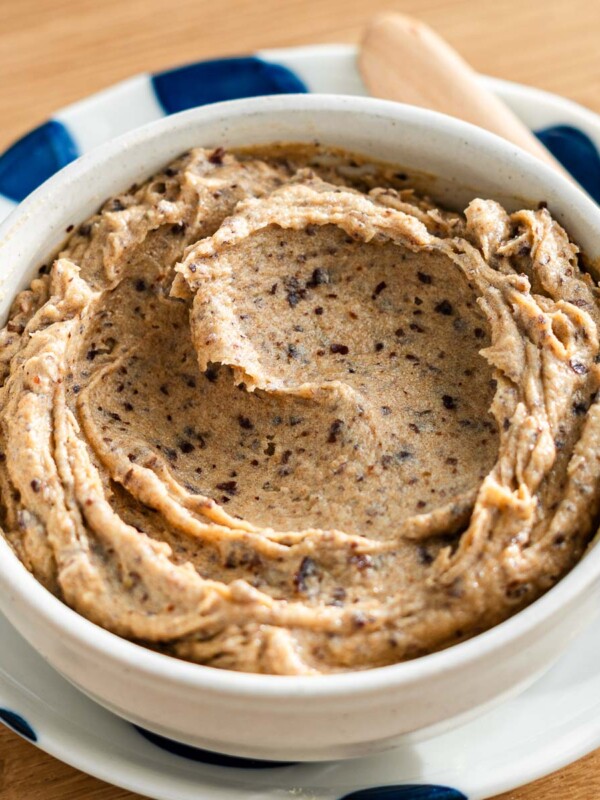 date butter in a bowl on a blue dotted plate with a butter knife beside it