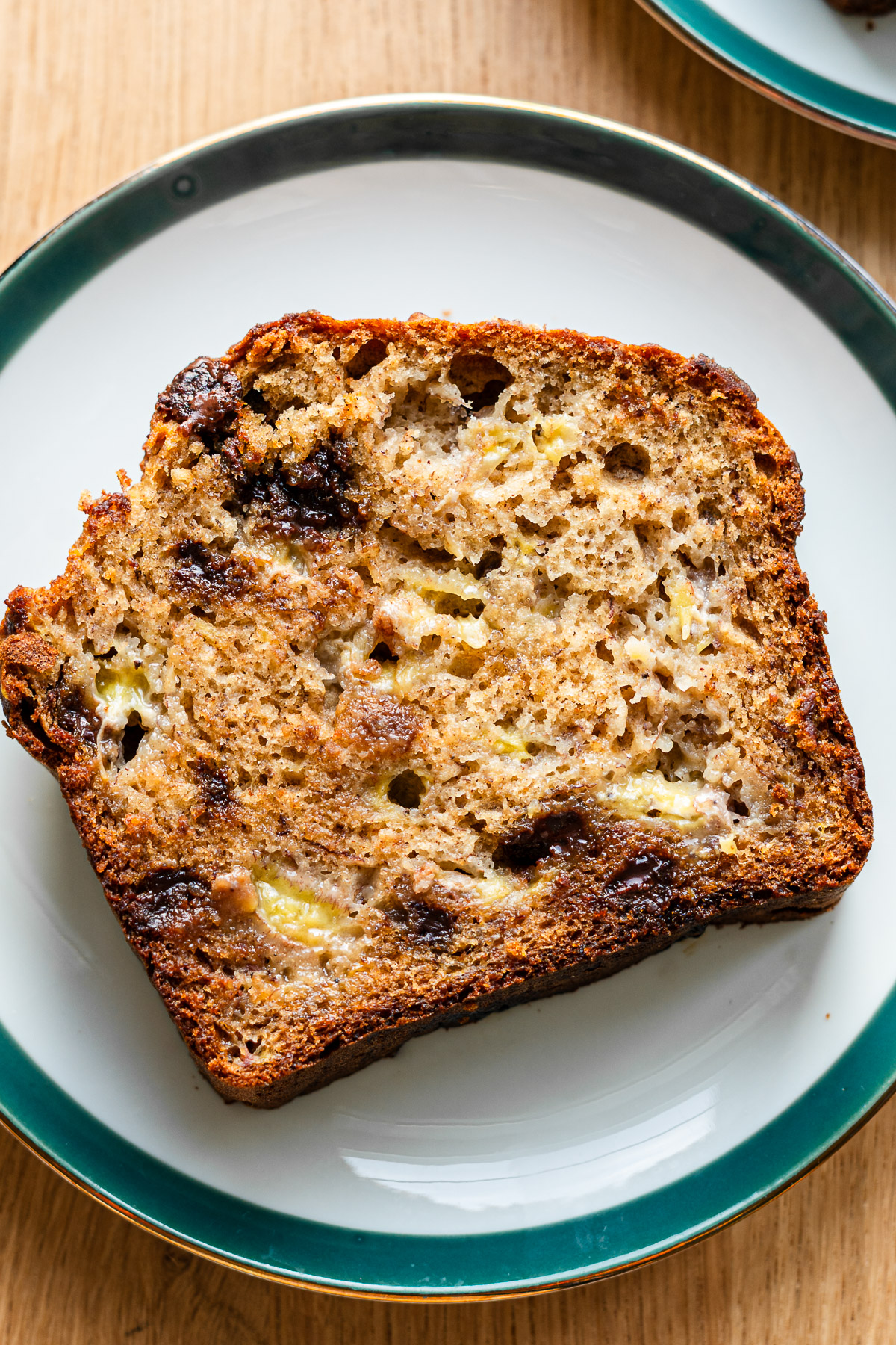 fluff and moist brown butter banana bread with chocolate chips on a green rimmed plate