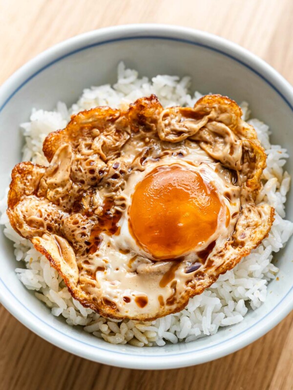 marinated sunny side up fried egg over rice in a blue japanese rice bowl