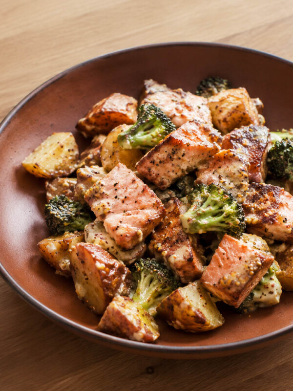 salmon potato salad with broccoli tossed in a creamy honey mustard dressing on a terracotta shallow bowl