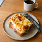 Corn Croque Monsieur on a beige ceramic plate. Shokupan with corn, broiled cheese with plenty of bechemel sauce.
